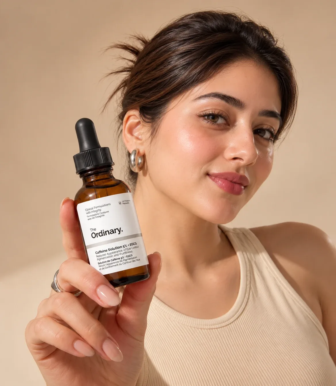 Woman holding The Ordinary Caffeine Solution 5% + EGCG